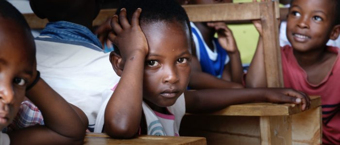 Photo by bill wegener boy in white shirt sitting on brown wooden desk chair